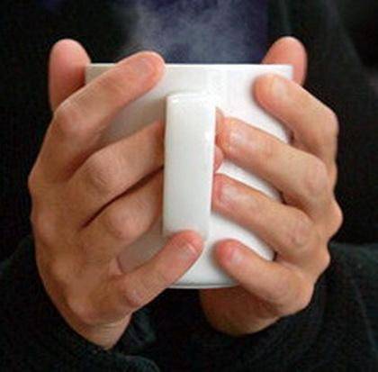 Selim has been out in cold weather and his hands feel frozen. He holds a cup of hot tea in his hands