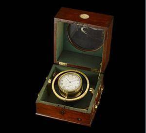 Text: It is made of brass and is around the size of a large pocket watch, with a normal clock dial