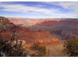 Analyze the photo below and answer the question that follows.

A desert area with cliffs and a can